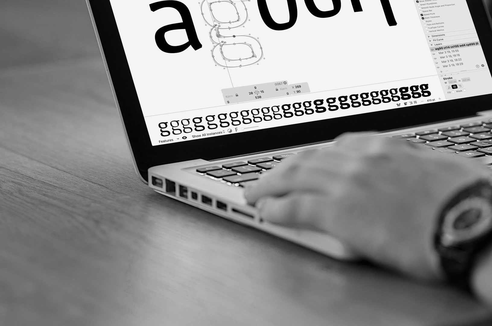 A person designing a typeface with a MacBook.